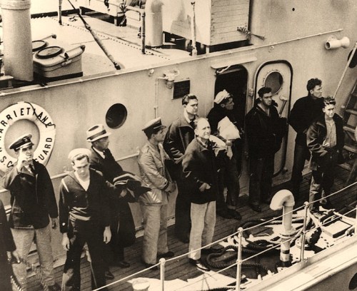 USS Squalus (SS-192) Rescue Operations, May 1939 Squalus' Commanding Officer, Lieutenant Oliver F. Naquin (center, hatless, wearing khaki pants), with other survivors on board the Coast Guard Cutter Harriet Lane, bound for the Portsmouth Navy Yard, Kittery, Maine, following their rescue, 25 May 1939.