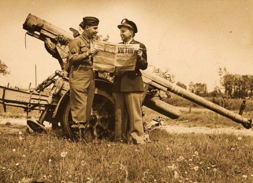 William R. Wilson (right) and brother Cpl. Jack Wilson (left) standing by a German 88 mm gun at Verdun, France on VE Day 